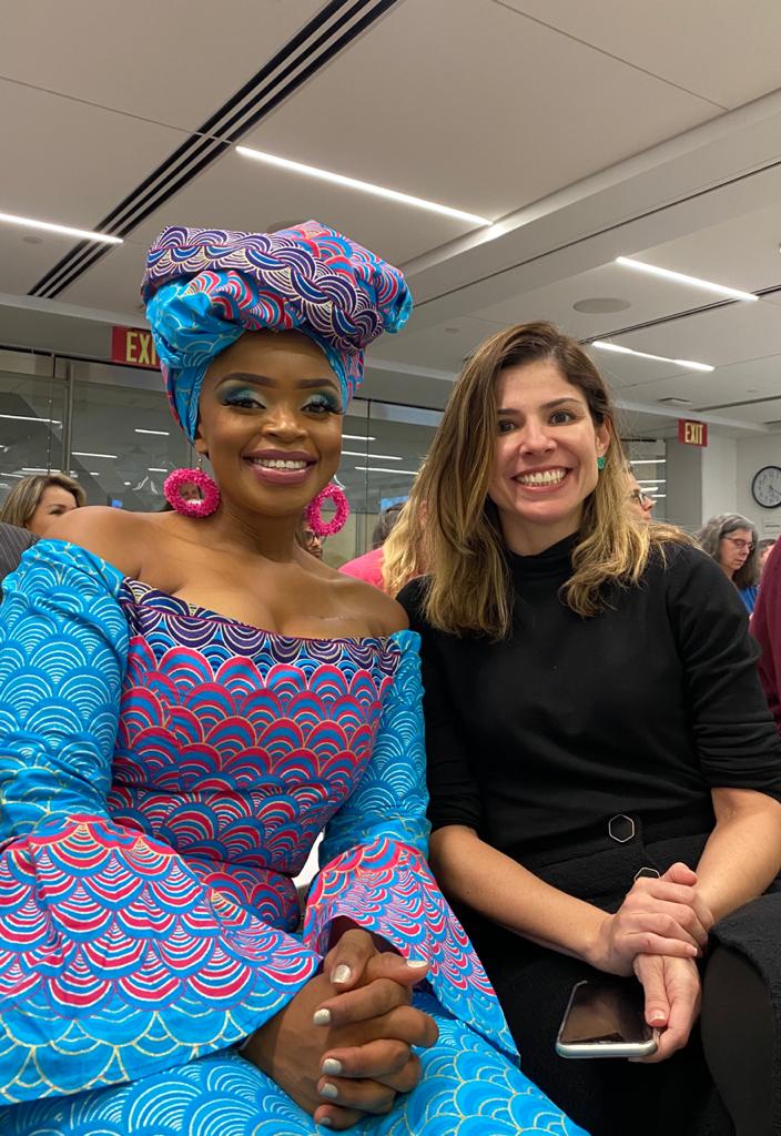 duas mulheres posam para a foto sorrindo